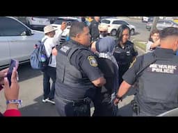 Protesting clergy at the ICE detention facility in Newark seen locking arms, blocking gate