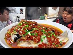 The fish head of a 20-jin silver carp is steamed in a pot with a can of chopped peppers from Monkey