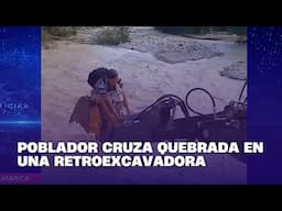 Poblador cruza quebrada en una retroexcavadora