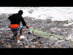 Con gran astucia, este pescador lanza su red entre grandes olas y el mar le entrega una sorpresa