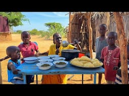 A  Beautiful family grinding   corn on the stone  to cook a simple nutritious food in the village