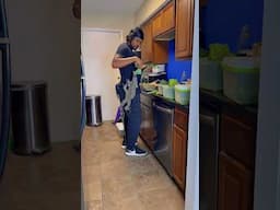 Iguana Climbing a Man in the Kitchen for Fresh Food