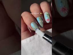 Blue shimmery nails with delicate floral details—pretty and full of charm. 💙 Credits: simlynail