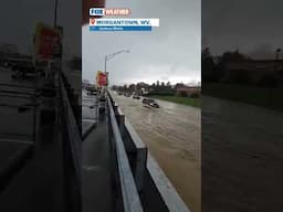 Vehicles drive on flooded road in West Virginia