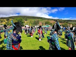 Ballater Pipe Band playing Cabar Feidh in crowds during 2024 Lonach Gathering Highland Games
