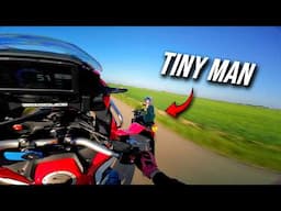 Africa Twin wheelie past small man…